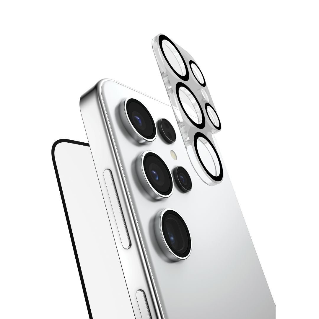 Close-up of a Samsung S25 Series smartphone with a rectangular shape and shiny silver metallic frame. The back panel shows multiple camera lenses and a flash. A RAPTIC Full Screen Camera Bundle - 2 in 1 Glass protector hovers above, highlighting the phone's buttons and slim profile.