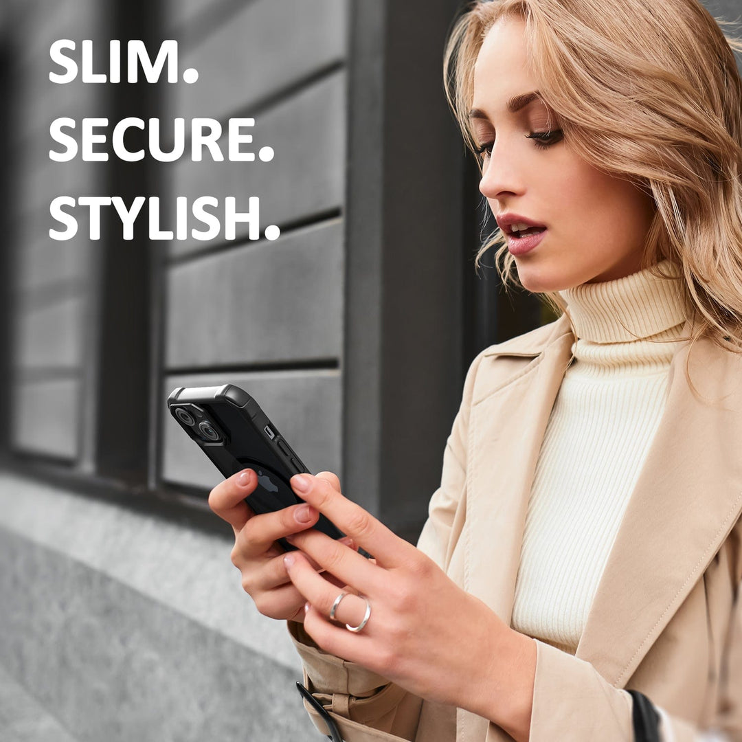 A woman with long blonde hair stands outdoors, wearing a beige trench coat over a white ribbed turtleneck sweater. She is looking at her smartphone while holding it with both hands. The background shows a building with large windows and gray walls. Text on the image reads: "SLIM. SECURE. MagSafe COMPATIBLE." featuring the Raptic Air Tough MagSafe Case for iPhone 15 from Raptic.