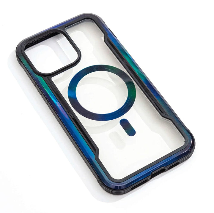 The Raptic Shield 2.0 iPhone 15 MagSafe Case by Raptic is showcased on a white background, featuring a clear design with a dark frame and a blue-green ring in the center, viewed from an angle. With compatibility for MagSafe accessories and providing up to 3-metre drop protection, this stylish case ensures both security and elegance for your device.