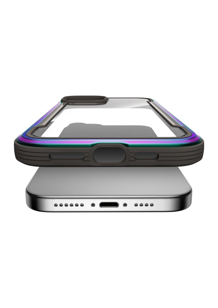 A smartphone with a Raptic Shield iPhone 15 Case is positioned above a wireless charging pad. The phone has a colorful protective case that offers 3-metre drop protection, and the charging pad is silver with a centered charging port.