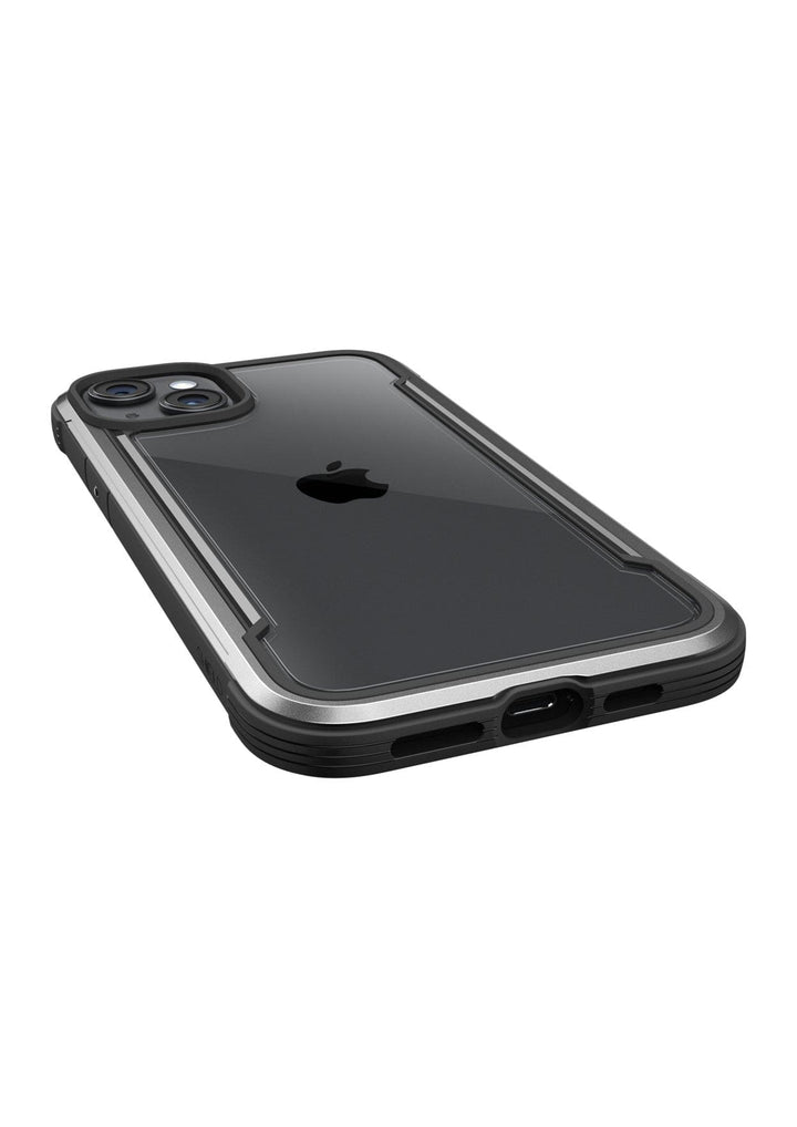 A black iPhone 15 in a protective clear Raptic Shield iPhone 15 Case with metallic edges is lying flat, showing its back with dual camera lenses and an Apple logo, offering 3-metre drop protection and meeting MIL-STD-810G Standards.