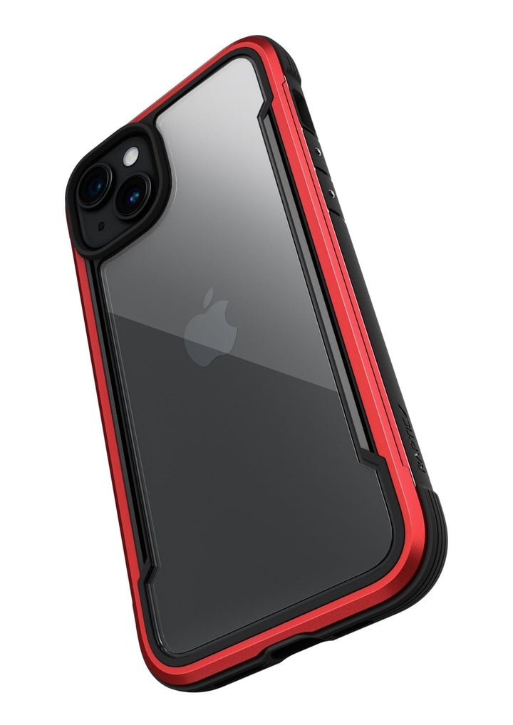 A smartphone with a clear back cover and red edges, designed as the Raptic Shield iPhone 15 Case, displays the Apple logo and meets MIL-STD-810G Standards for up to 3-metre drop protection.