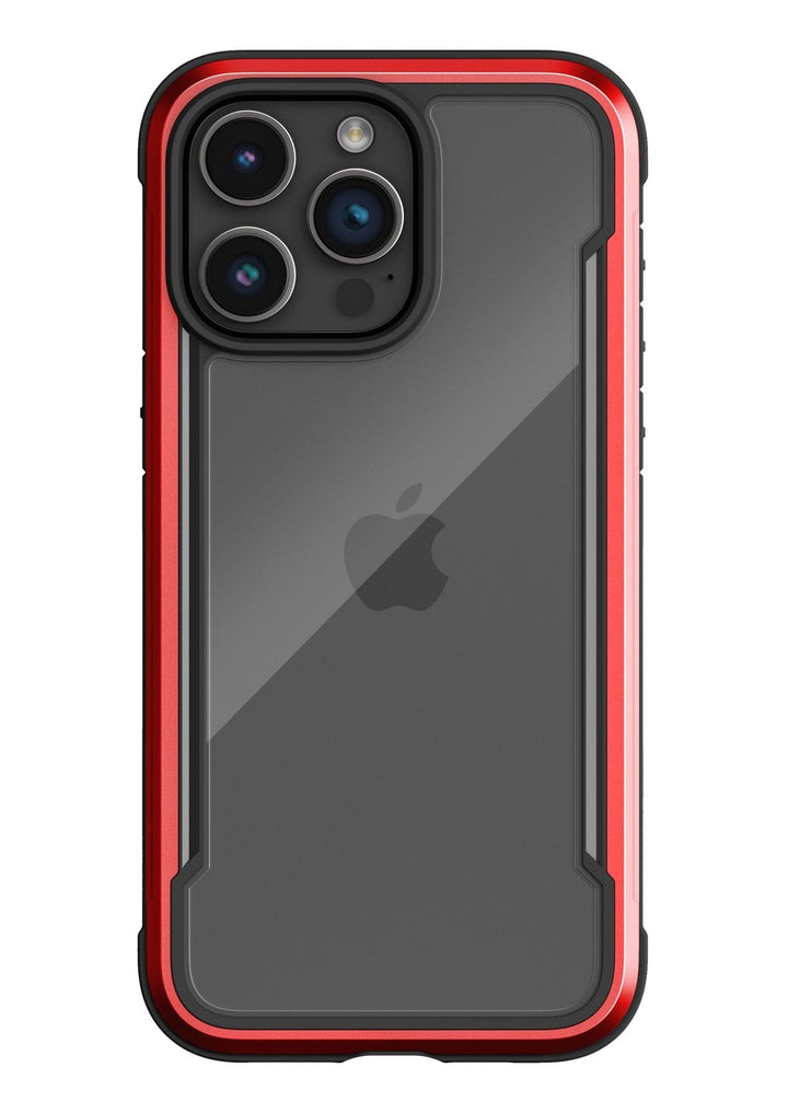 A smartphone with a triple-lens camera in a red and black Raptic Shield iPhone 15 Shield Case, featuring a visible Apple logo on the back and 3-metre drop protection adhering to MIL-STD-810G Standards.