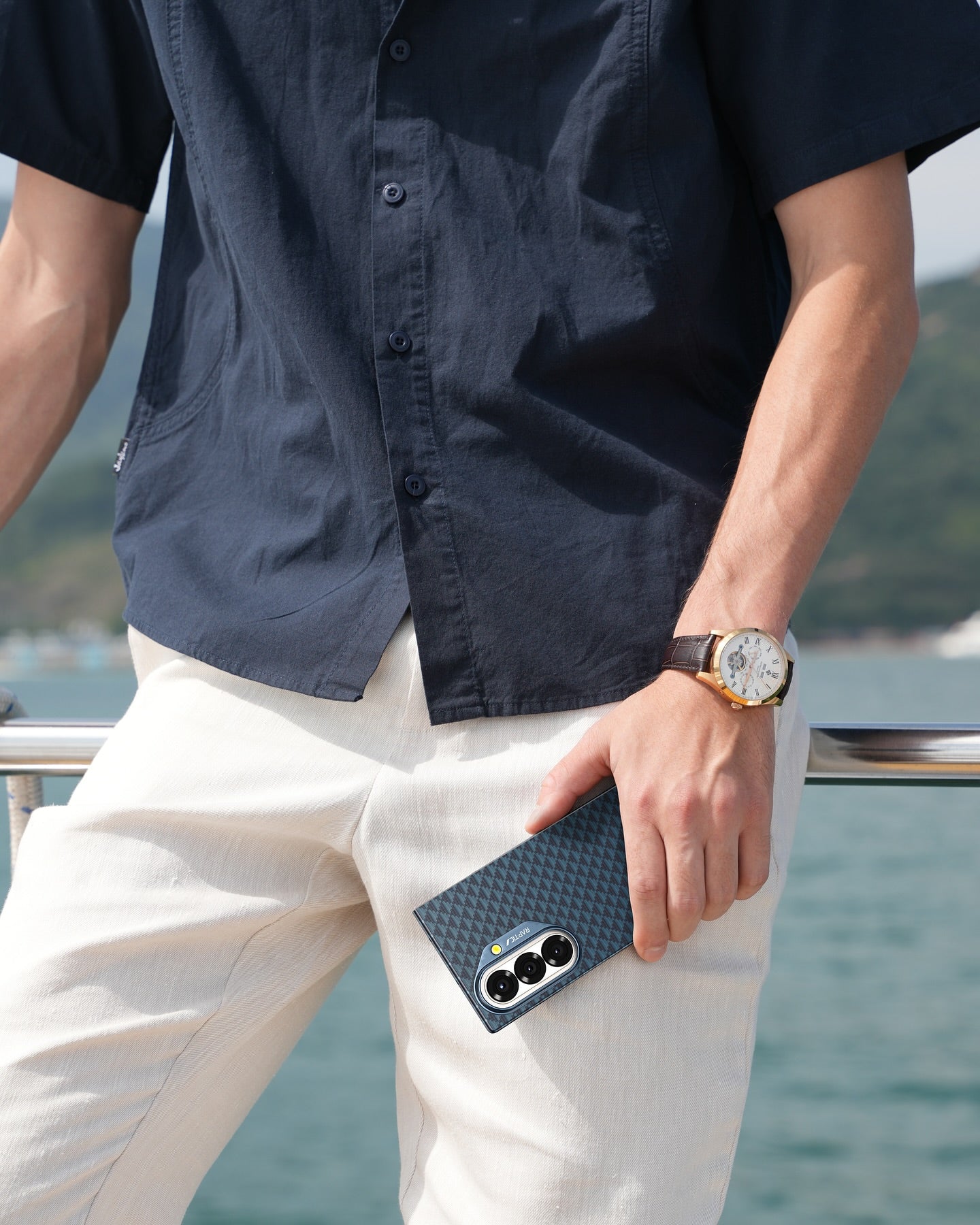 Person holding a Raptic Galaxy Z Fold 7 case with a scenic background