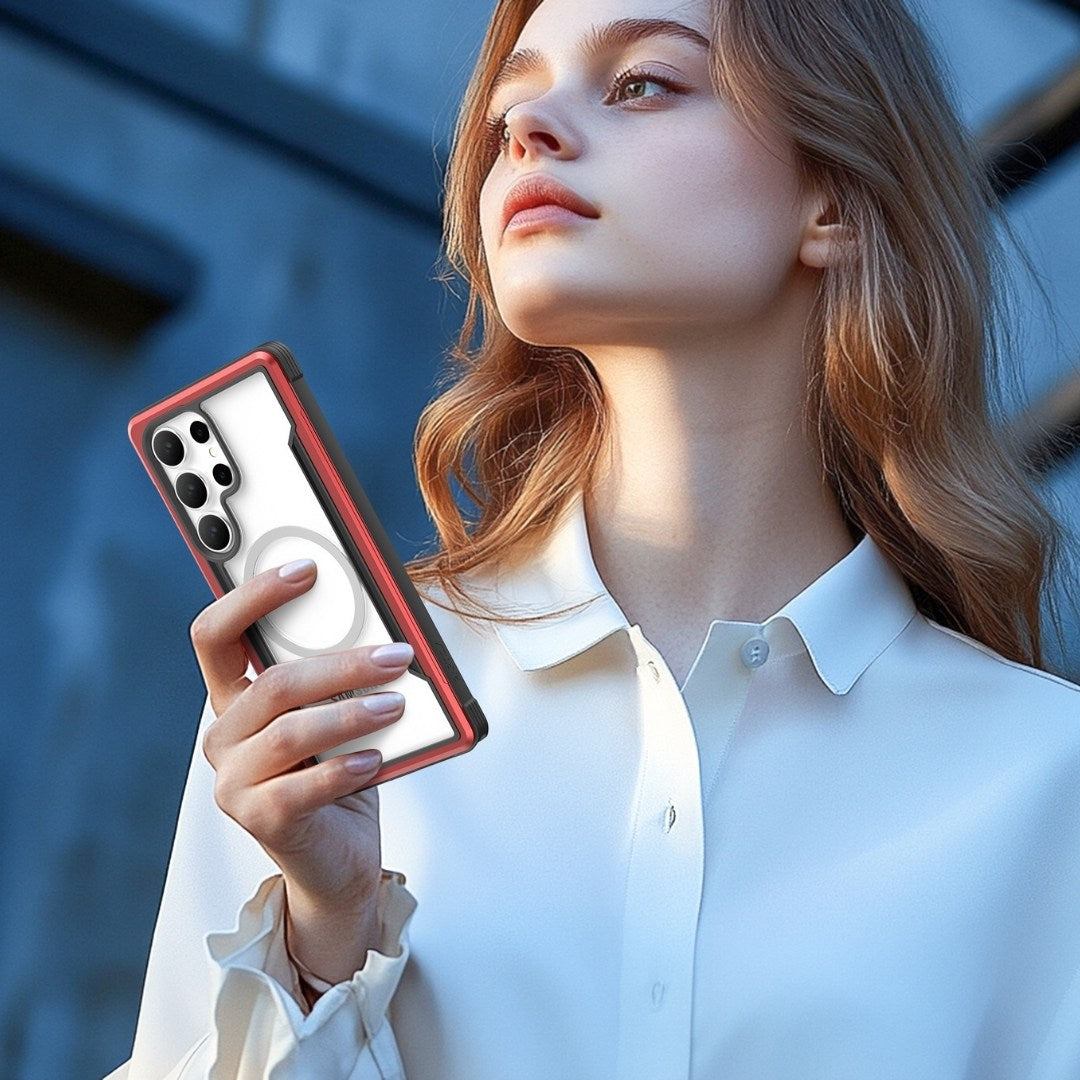 A young woman in a white blouse holds a Samsung Galaxy S25 in its Raptic Shield case with military-grade protection. Featuring shock absorption and a distinctive red and black design, she gazes upward against a blurred outdoor backdrop of architectural elements.