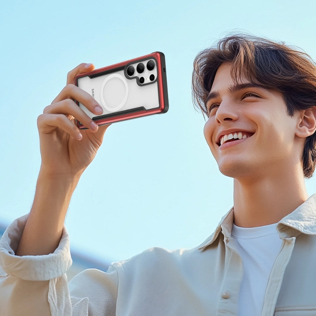 A smiling person with brown hair holds a Raptic Shield Galaxy S25 case. The red, military-grade, shock-absorbent case is angled for a photo. They're in a beige jacket over a white shirt against a clear blue sky, creating a cheerful outdoor scene.