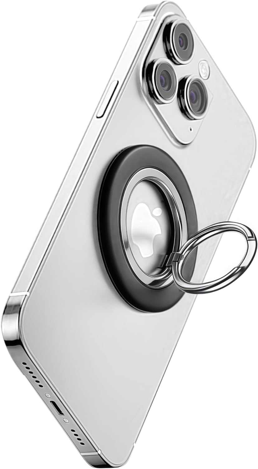 A silver smartphone with three rear cameras has the MobileTechnica Magnetic Ring with Pop holder - Raptic Defeme, a black circular magnetic stand, attached to its back. The ring is upright and rotatable, showing the Apple logo against a white background.