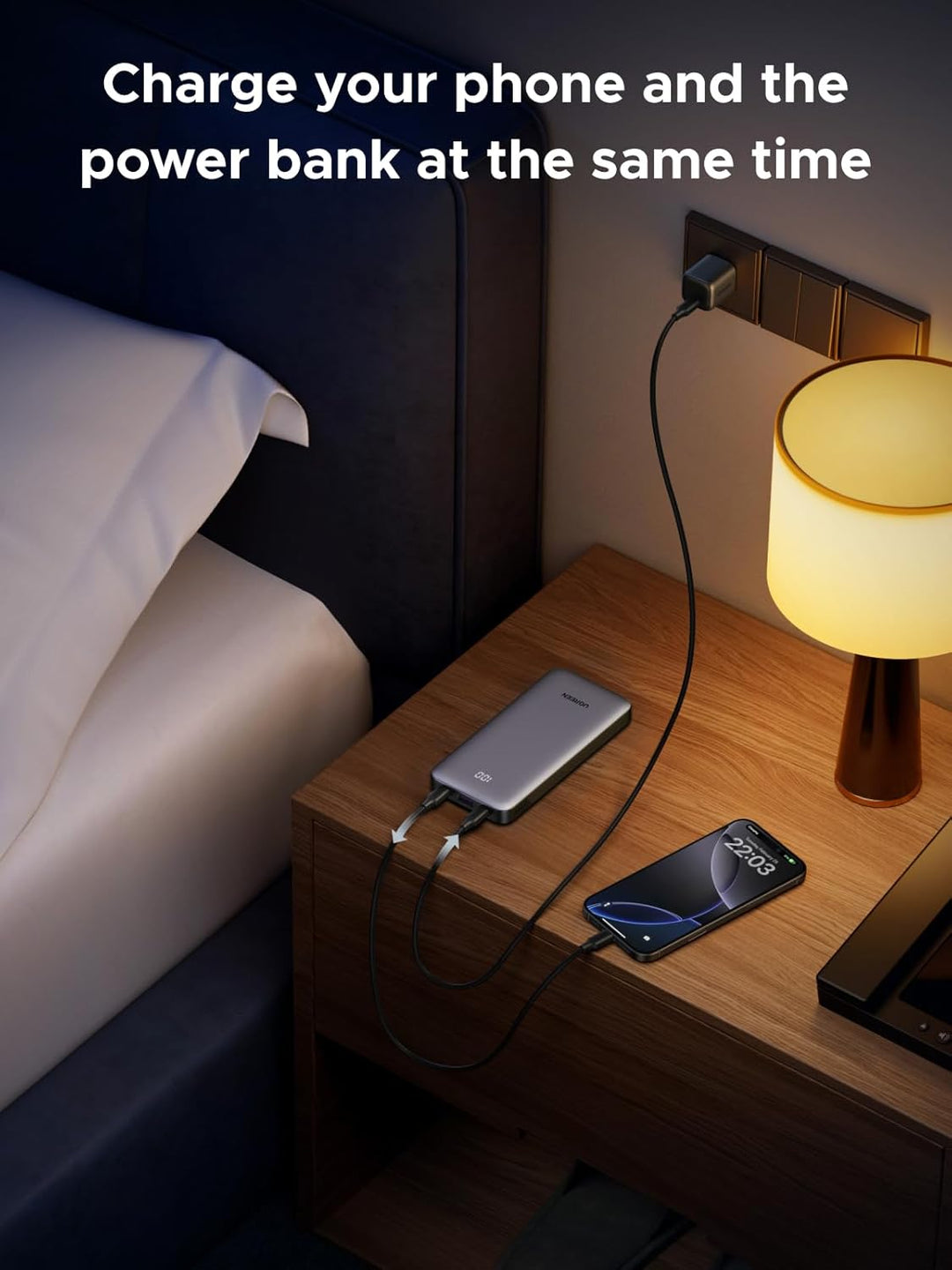 A UGREEN Slim Power Bank 10000mAh 30W charges from a wall outlet on a nightstand while fast charging a phone. Both devices are connected, with text above: "Charge your phone and the power bank at the same time.