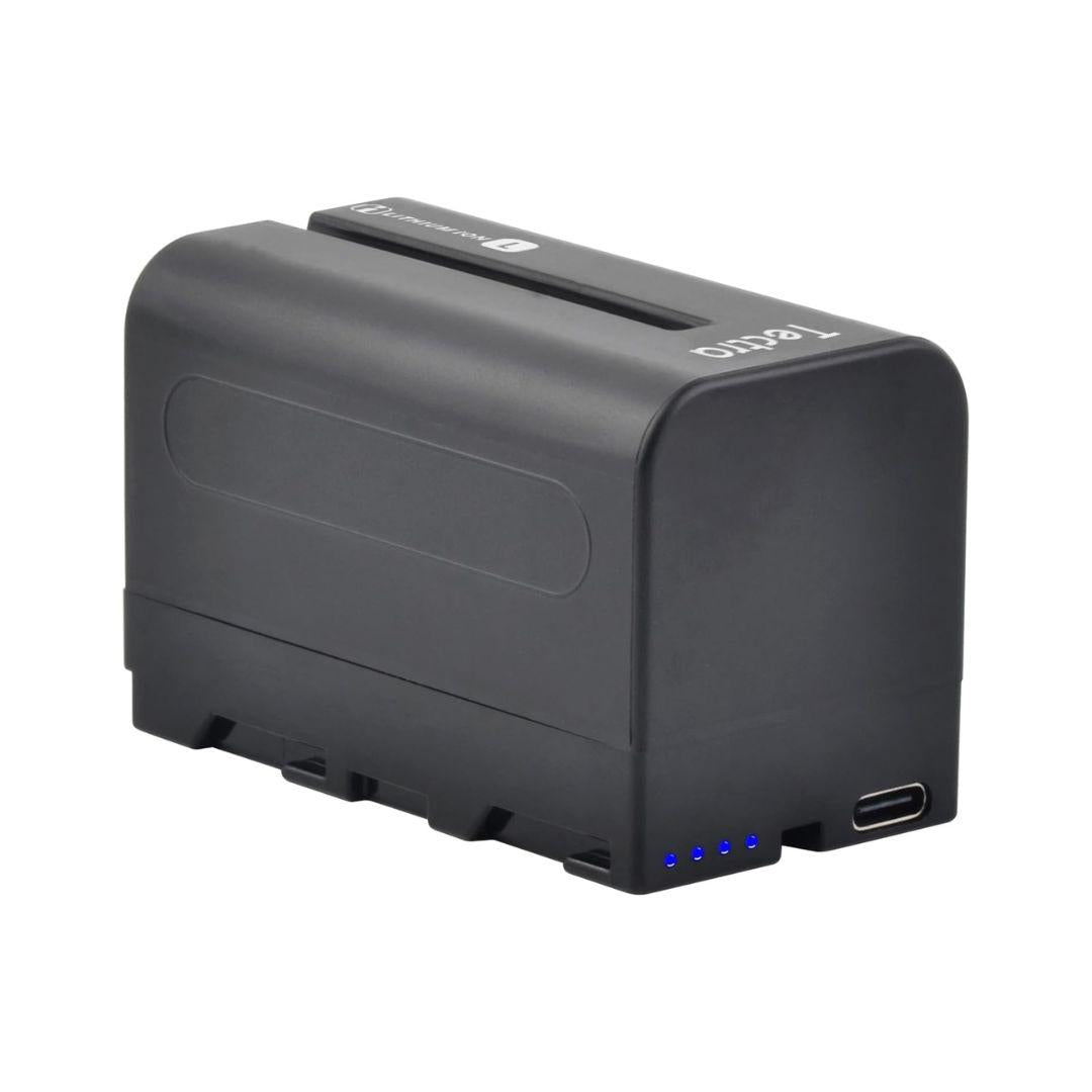 The MobileTechnica Tectra 6000mAh Battery for Sony NP-F970/F750/F550 (2-pack) is a black, rectangular NP-F battery with a smooth finish, four blue LED indicators, USB-C port, and ridged detailing along the bottom edge.