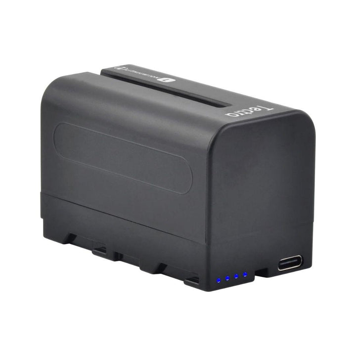 The MobileTechnica Tectra 6000mAh Battery for Sony NP-F970/F750/F550 (2-pack) is a black, rectangular NP-F battery with a smooth finish, four blue LED indicators, USB-C port, and ridged detailing along the bottom edge.
