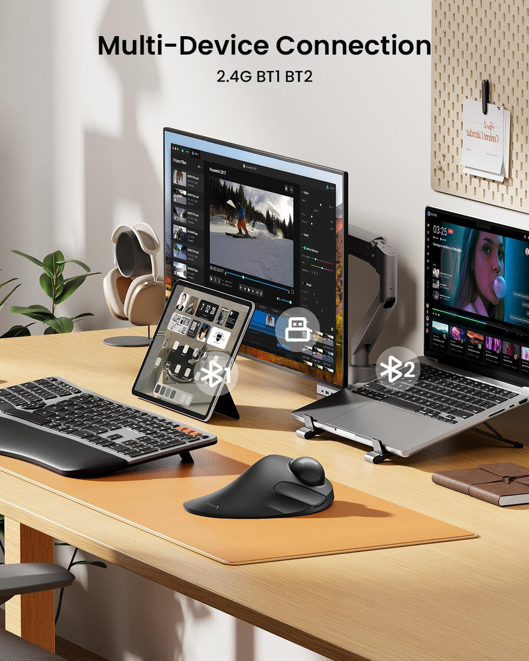 A sleek desk shows the MobileTechnica ProtoArc EM03 Wireless Trackball Mouse (Mac-Gray) alongside a keyboard, tablet, monitor, and laptop. The screen reads "Multi-Device Connection 2.4G BT1 BT2," emphasizing its ergonomic design and triple device connectivity.