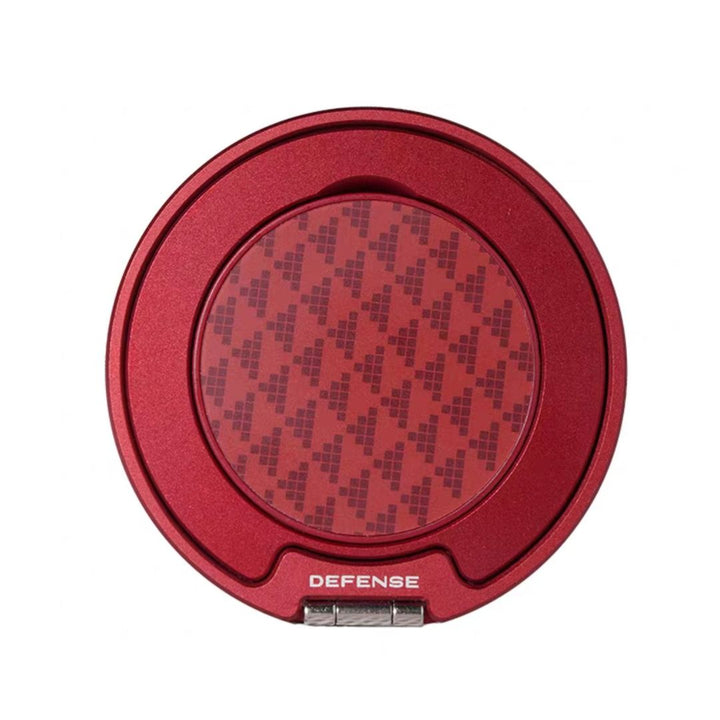 A red, round "MobileTechnica" case with a transparent lid and white "DEFENSE" branding reveals a black plus sign pattern inside. This Magnetic Ring with Pop holder—Raptic Defense—pairs perfectly with any 360° phone ring.