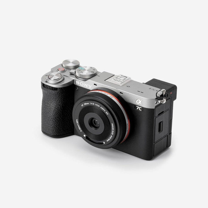 A Sony Alpha 7C mirrorless camera with a black textured grip is shown on white, equipped with a Viltrox 28mm f/4.5 FE wide-angle lens for Sony Full Frame cameras, featuring fast autofocus and multiple top dials and buttons.