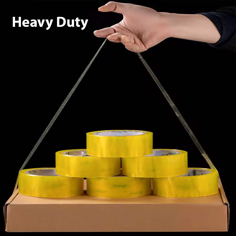 A hand holds a thin, taut wire connected to a triangular arrangement of six MobileTechnica Clear Packaging Tape rolls with strong adhesion, resting on a rectangular cardboard box against a black background. White text in the top left corner reads "Heavy Duty.