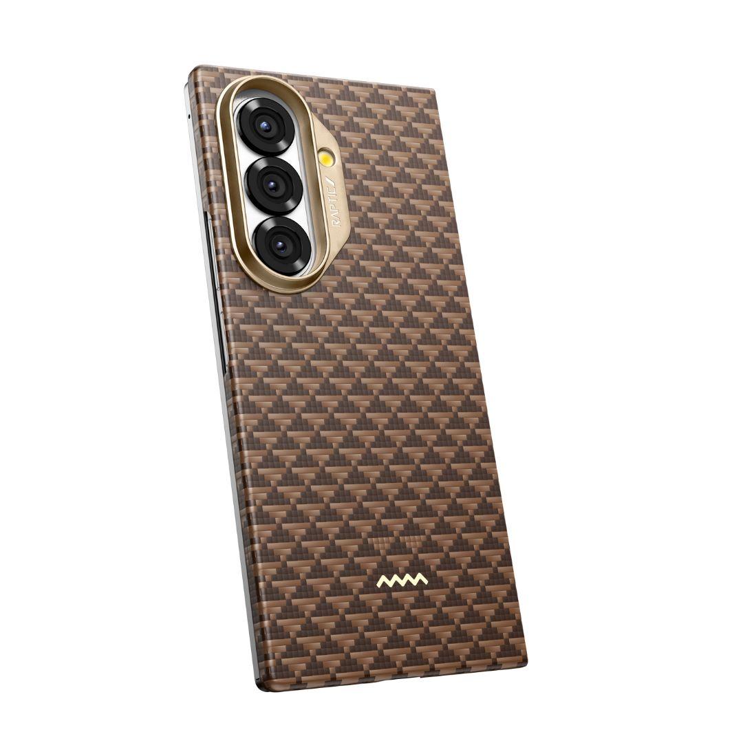 The RAPTIC Samsung Galaxy Fold 7 Skin Case – Humble Desert features brown and black carbon fiber style, gold-trimmed triple camera cutout, a woven pattern, hinge protection, a white logo at the bottom center, and is pictured at an angle.
