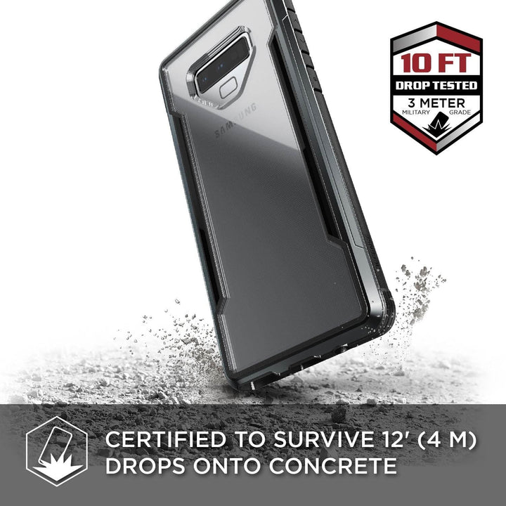 A Samsung Galaxy Note 9 encased in the Raptic X-Doria Defense Shield is shown surviving a drop test from 10 feet (3 meters) onto concrete. Accompanying text states the certification for surviving drops from 12 feet (4 meters) while being fully wireless charging compatible.